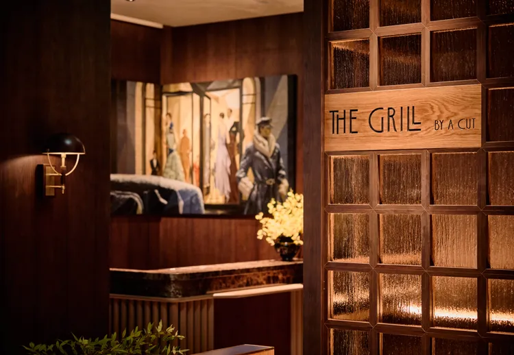 The Grill by A CUT入口以深色花梨木、琥珀色壓花玻璃及金屬線條，營造優雅而獨具儀式感的迎賓場景。國賓大飯店提供