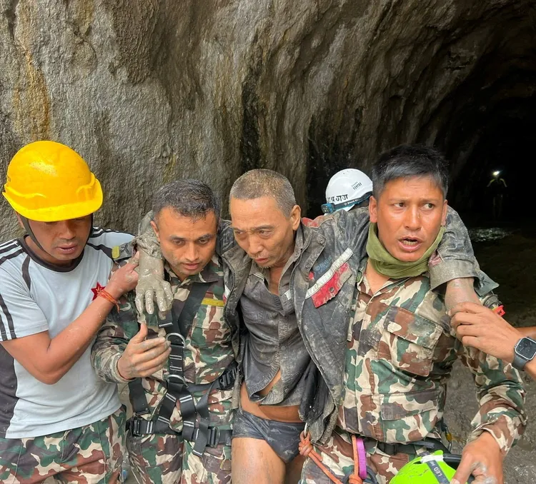 尼泊爾救災人員救出1名中國工人（右二）。路透社