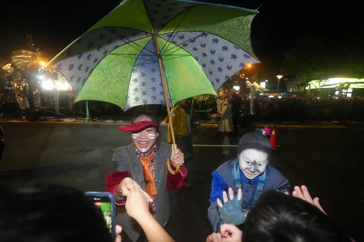 3頭大象在樂隊簇擁下踏上台北士林街頭，劇團演出人員也近距離與圍觀民眾互動。中央社