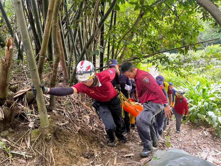 警消合力以擔架抬運至平面道路。龜山警分局提供