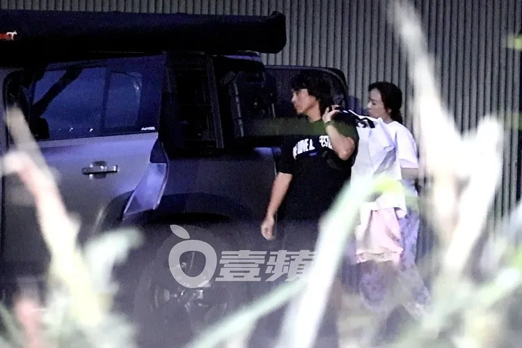 王仁甫將當天拍攝用的衣服背在肩上，和季芹回到頭城社區。特勤中心攝