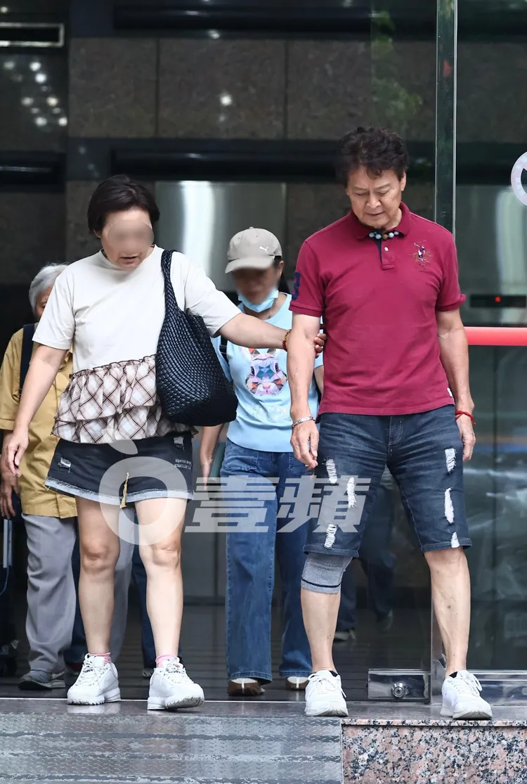 劉尚謙（右）與熟女步出大樓下階梯，她自然地抓住他的手臂幫忙穩住步伐。特勤中心攝