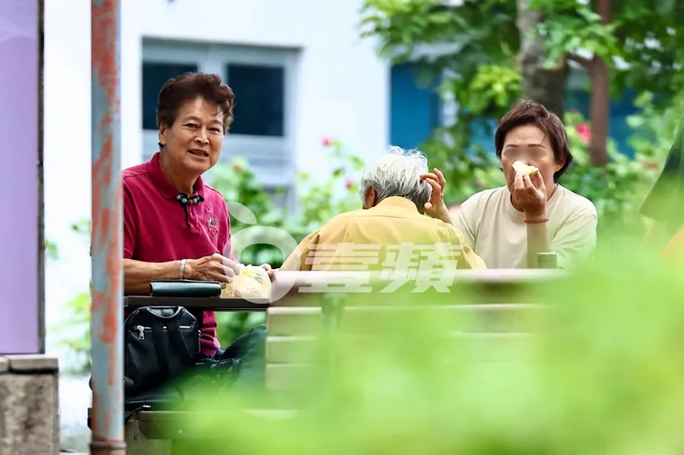 劉尚謙（左）找到公園桌椅，拿出熟女準備的食物，開心和婆婆媽媽們野餐。特勤中心攝