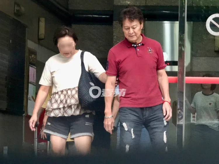 劉尚謙（右）在女友人溫柔攙扶下，步出商辦大樓。特勤中心攝