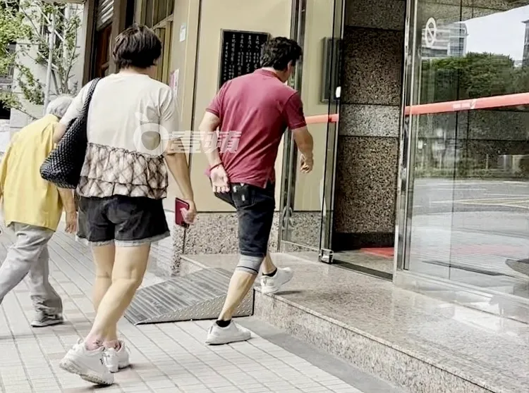 劉尚謙（右）帶隊走進承德路商辦大樓拜訪友人。特勤中心攝