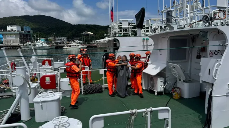 潛水客在海水泡的時間過久恐失溫，海巡隊員幫忙裹上毯子取暖。翻攝畫面