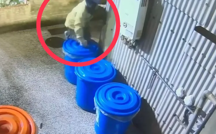鄧嫌犯案前爬上垃圾桶切斷監視器線路。翻攝畫面