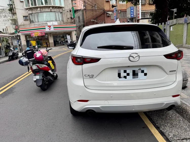 白色馬自達突然開車門害騎士摔車。翻攝畫面