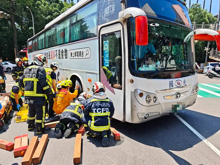消防人員搶救受困車底的婦人。民眾提供