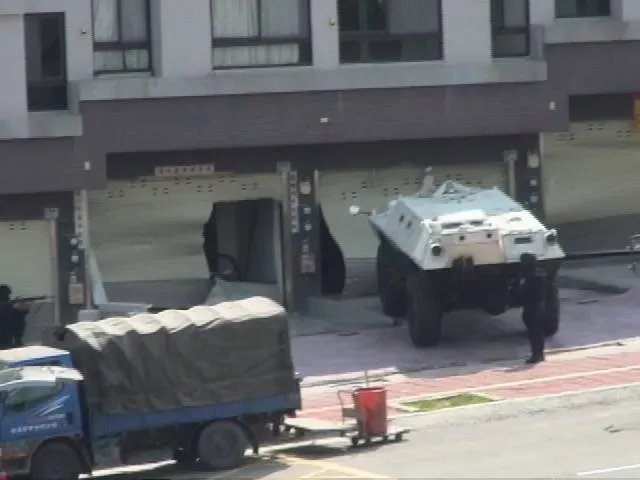警方當年出動裝甲車直衝張錫銘藏匿處1樓鐵捲門攻堅。翻攝臉書社團CIB局長室