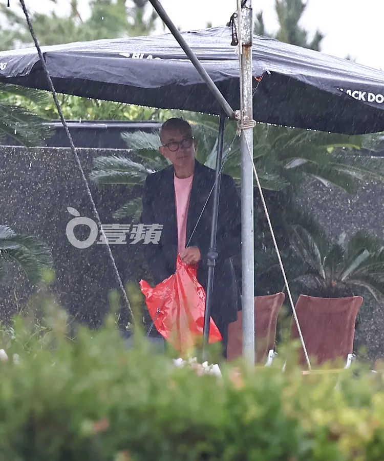具俊曄拿著紅色塑膠袋收拾東西。特勤中心攝