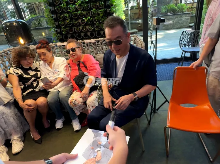 資深影帝張晨光（右）親切和師奶粉絲坐在一塊，粉絲拿帥照要簽名來者不拒。特勤中心攝