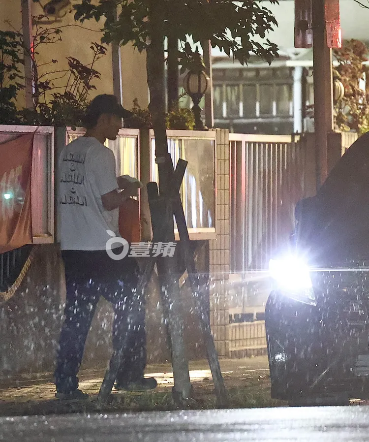 阮經天冒雨快步從家裡拿出禮盒遞給車內的柴曉倩。特勤中心攝