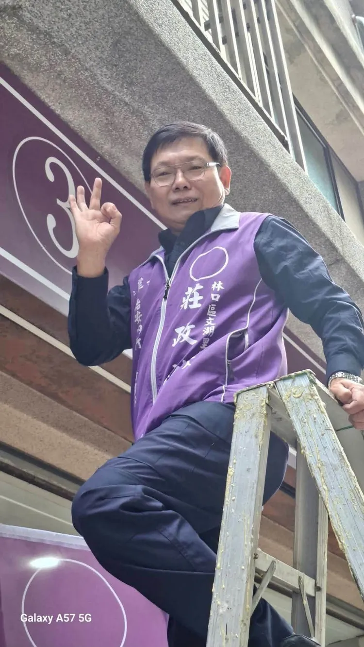 莊政裕親自為競選總部貼上號次，並比OK手勢為自己加油打氣。翻攝自臉書