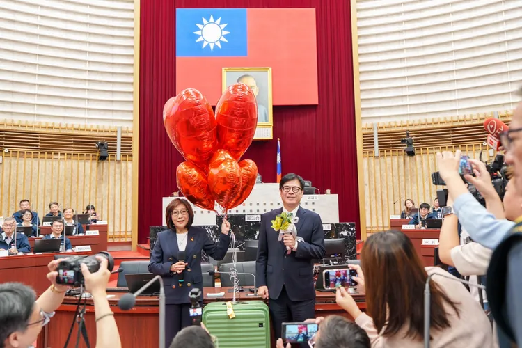 議長康裕成特別準備藍牙伴唱麥克風及繫著六顆紅色氣球的行李箱，象徵陳其邁六年市長任期的耕耘與祝福。翻攝畫面