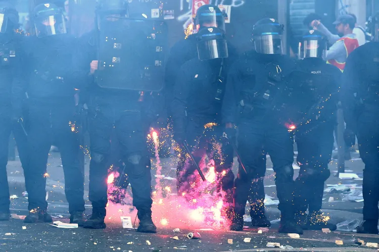 法國學生在巴黎示威期間與警方爆發衝突，煙火在法國共和國保安隊鎮暴警察附近炸開。路透