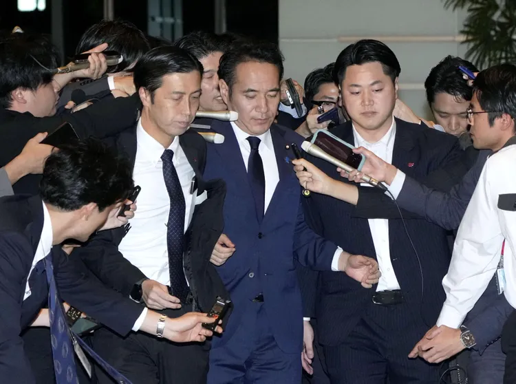 簗和生前往首相官邸遞交辭呈，受到媒體包圍。路透社