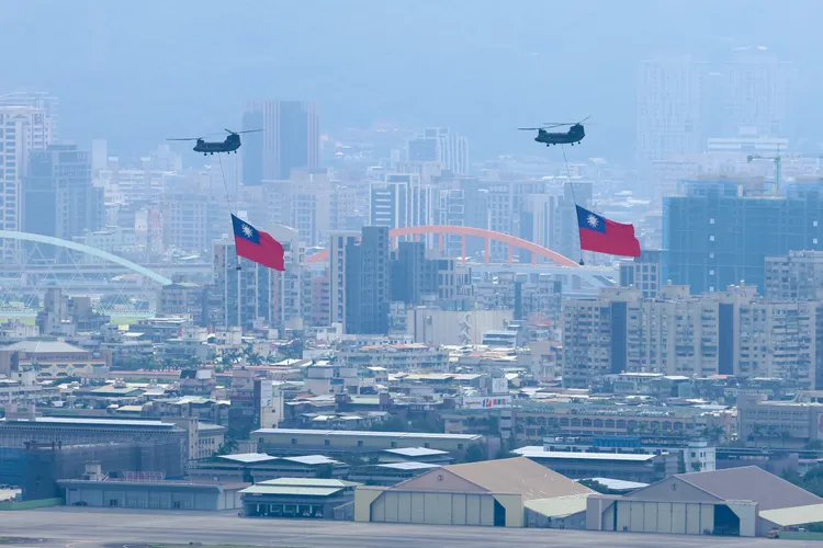 國旗機隊以CH-47契努克直升機吊掛巨幅國旗，並伴隨2架UH-60M黑鷹直升機通過總統府上方。彭欣偉攝影