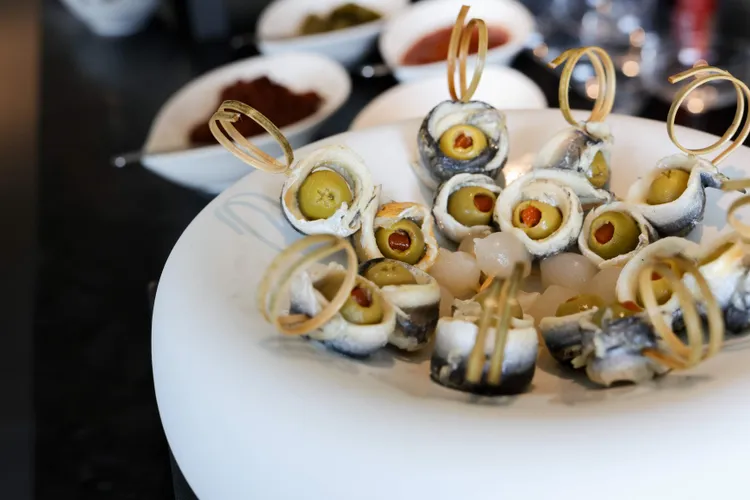 六週年慶「Wellness 五感療癒盛典」由星級餐廳渥達尼斯磨坊主廚製作 Party Food 西班牙橄欖鯷魚串。業者提供