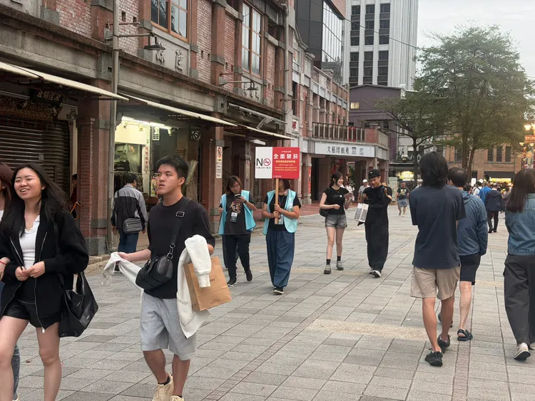 大稻埕迪化街商圈周邊確實有工作人員舉牌提醒民眾此處禁煙。壹蘋新聞網攝