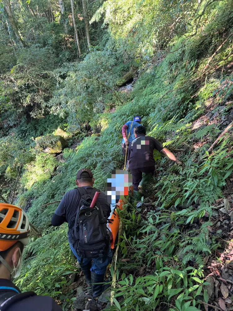 警方會同義警、義消及葬儀社人員合力將遺體搬運下山。翻攝畫面