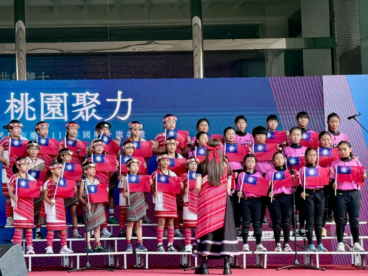 僑愛國小太陽之愛合唱團，攜手新屋國小女壘隊領唱國歌。民政局提供
