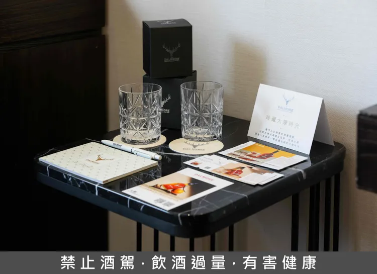 「慕舍×大摩」聯名主題房-迎賓禮贈組：包含大摩15年及亞歷山大三世威士忌兌換券(20ml)，精緻威杯、專屬用筆及小卡手冊等。業者提供