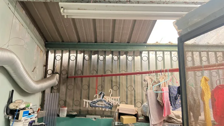 王先生說，他家後陽台只有遮雨棚，沒有加蓋違建，後巷接管最省成本，卻因多數鄰居有違建改前巷接管。鮮明攝