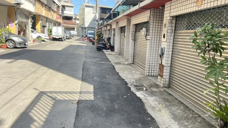 王先生因多數鄰居後陽台蓋違建，污水下水道從後巷接管改成前巷接管，導致自付費用暴增3倍，施工單位已在其門前埋管。鮮明攝