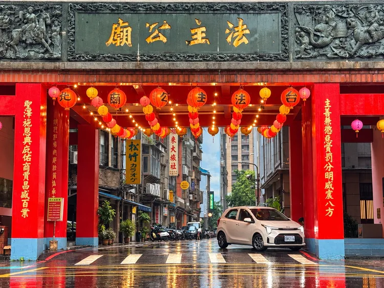 雨中的南京西路法主公廟，傳統廟宇與現代車流並存，也成為這趟老台北尋訪之旅的第一站。林浩昇攝