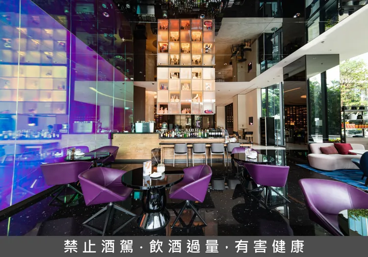 台北士林萬麗酒店 R bar 逸庭以現代設計結合紫色座席與通透空間，營造兼具時尚感與舒適氛圍的酒吧環境。賓客可於此相約小酌，搭配萬聖節限定「鍊金術師」調酒組合，感受節日限定的品飲樂趣。業者提供