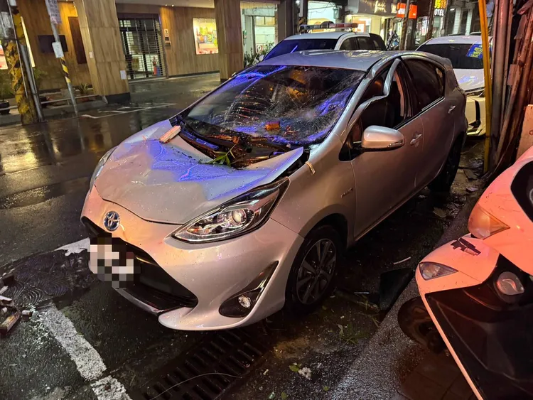 租賃車遭招牌砸中，導致車身出現嚴重損毀。翻攝照片