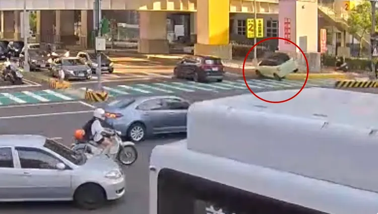 路口監視器拍下轎車衝上分隔島驚險一幕。翻攝畫面