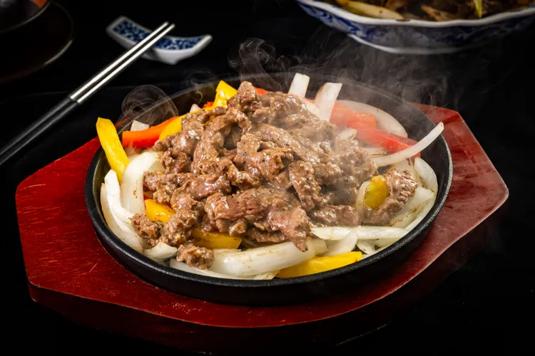 單點「鐵板炙香牛」上桌冒著騰騰熱氣，堪稱下飯神器。二本松餐飲集團提供