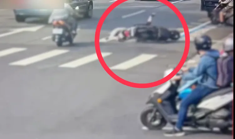 陳男(紅圈處)變換車道不慎摔車，貼地滑行撞上一旁買早餐後要離開的王男機車。翻攝畫面
