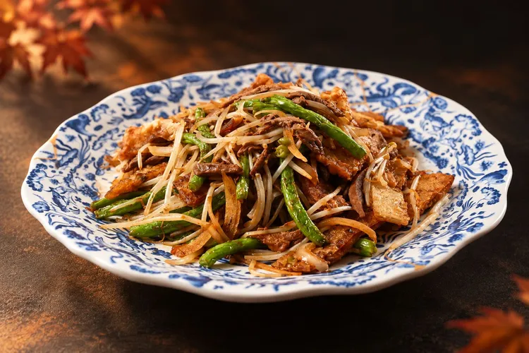 王朝中餐廳招牌「凱撒桃木片皮鴨四吃」之一的「銀芽鴨絲炒餅」，以鴨肉搭配銀芽與四季豆拌炒，融合鴨肉的鹹香、銀芽的爽脆與四季豆的清甜，呈現豐富味覺層次。台北凱撒大飯店提供
