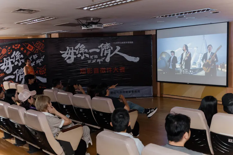 頒獎現場放映〈毋係一儕人〉官方MV。客家局提供
