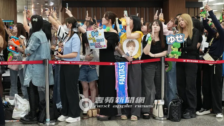 近500名粉絲高舉手幅、成員娃娃接機。彭欣偉攝