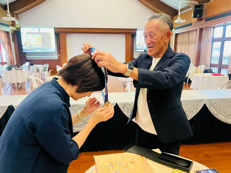 曾野政男替唐美雲戴上金牌。唐美雲歌仔戲團提供