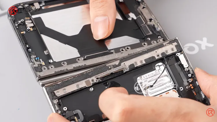 iPhone Duo拆解畫面可見，兩側機身透過排線連接，轉軸周圍配置多處固定結構，拆裝時須留意排線走向與零件位置。REWA Technology YouTube