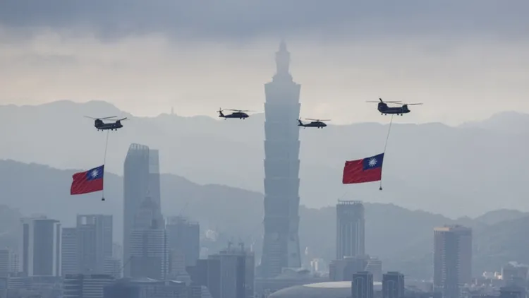 陸軍CH-47SD契努克運輸直升機吊掛巨幅國旗，與UH-60M黑鷹直升機組成國旗機隊，飛往總統府方向。中央社