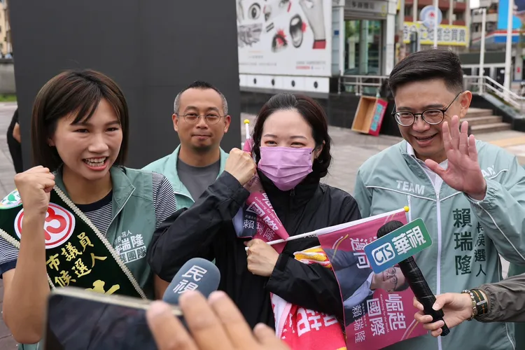 賴瑞隆29日上午街頭拜票，一位熱情民眾（中）也加入拜票。翻攝畫面