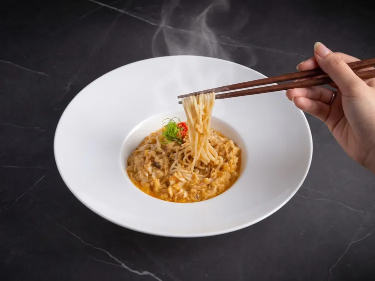上海醉月樓「蟹粉撈細麵」將大量現拆生蟹黃高溫拌炒至油亮生香，每根手工細麵均勻掛足濃醇蟹脂，入口黏嘴生香，回味悠長。台北遠東香格里拉提供