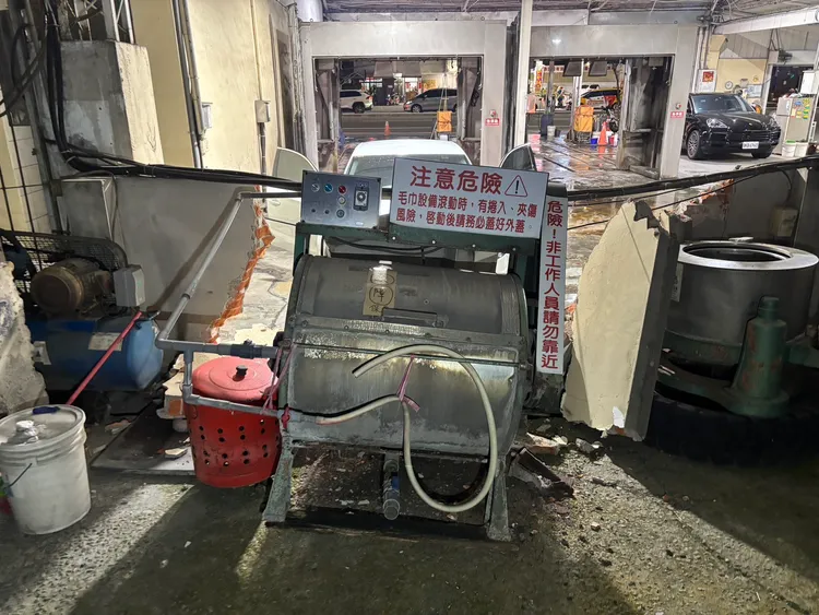 賴女誤踩油門，衝毀洗車場圍牆。警方提供
